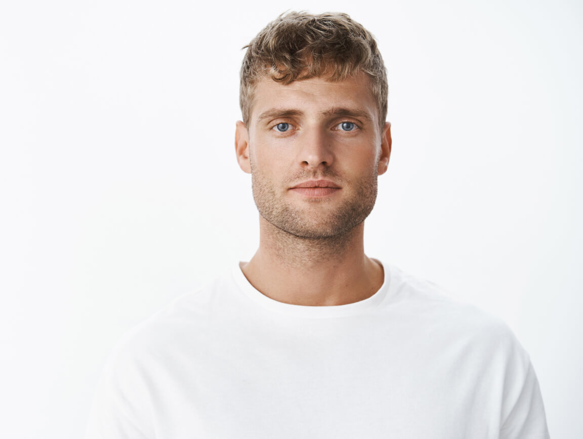 Waist Up Shot Handsome Calm Blond Blue Eyed Guy With Bristle White T Shirt Looking Front With Relaxed Carefree Facial Expression Posing Gray Wall Looking Sincere Chill 1 1
